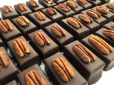 Multiple pieces of chocolate with pecan on top